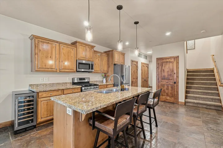 Kitchen featuring wood cabinetry, stainless steel appliances, a center island with countertop seating, and recessed lighting