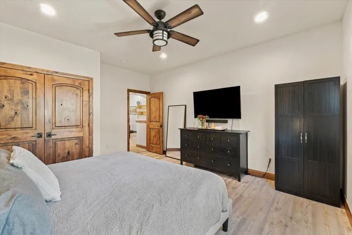 Wood-finish flooring, recessed ceiling lighting, and a ceiling fan with light fixture