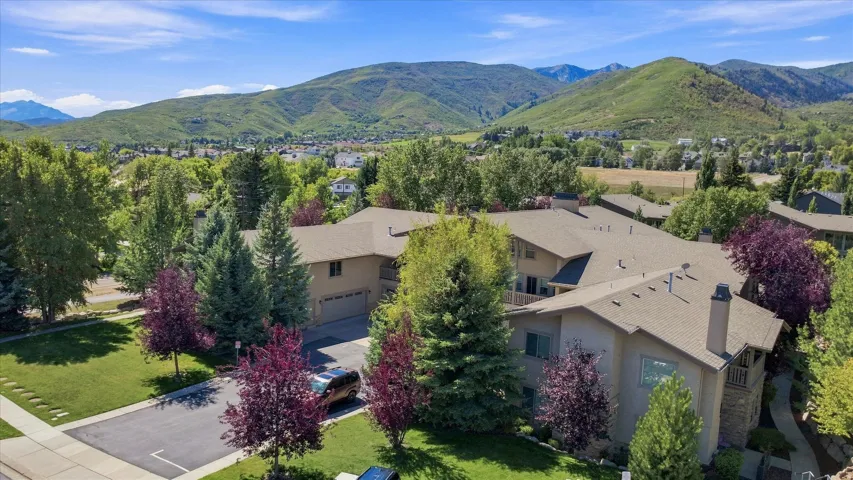 Expansive property featuring mature trees, landscaped lawns, and mountain scenery