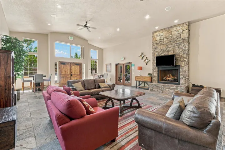 Vaulted ceilings, a stone-finish fireplace, and natural light from multiple windows