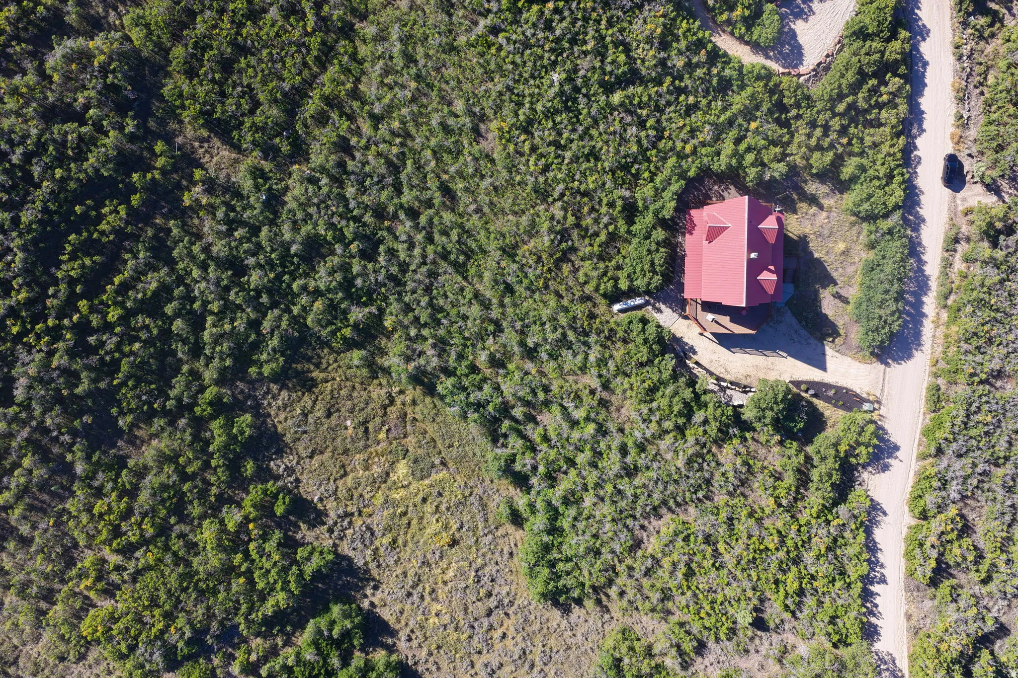 Red-roofed residence nestled amongst extensive natural landscaping
