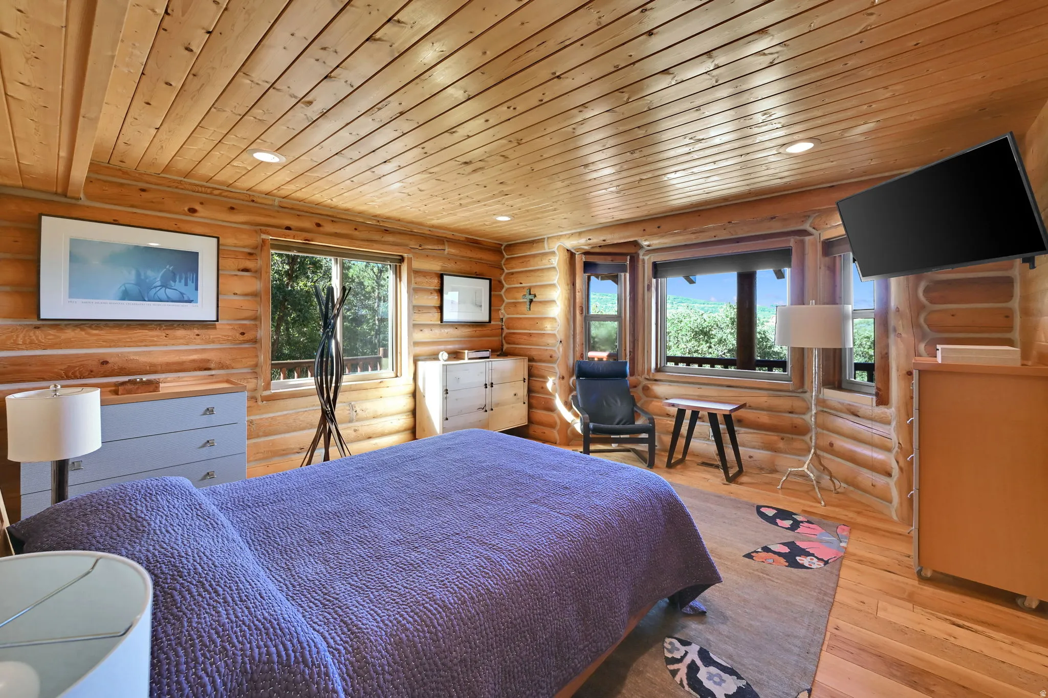 Wood-finish flooring, wood-paneled walls, wood-paneled ceiling, recessed lighting, and multiple windows