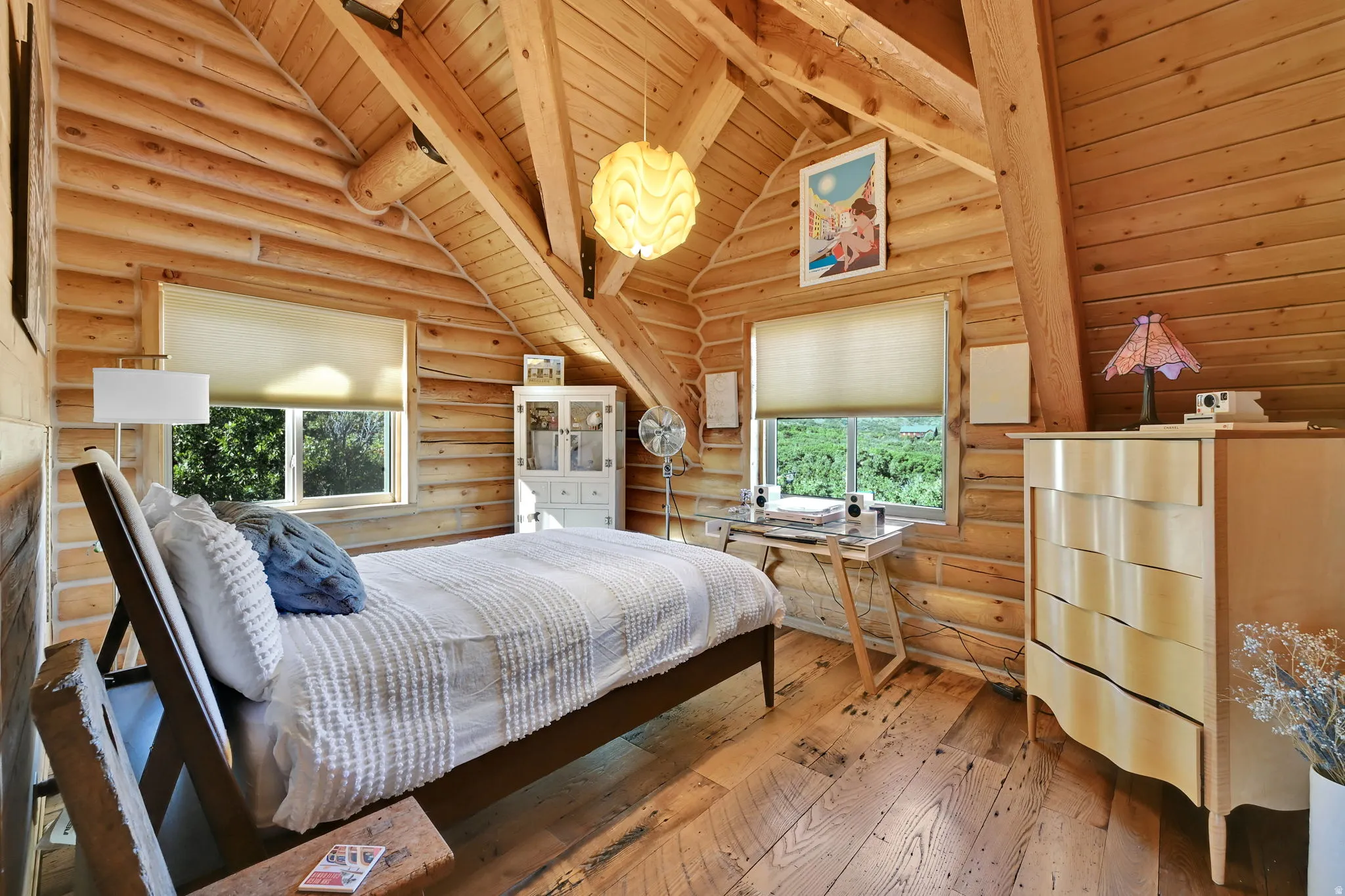 Exposed wood-beam vaulted ceiling, log walls, and wood-finish flooring