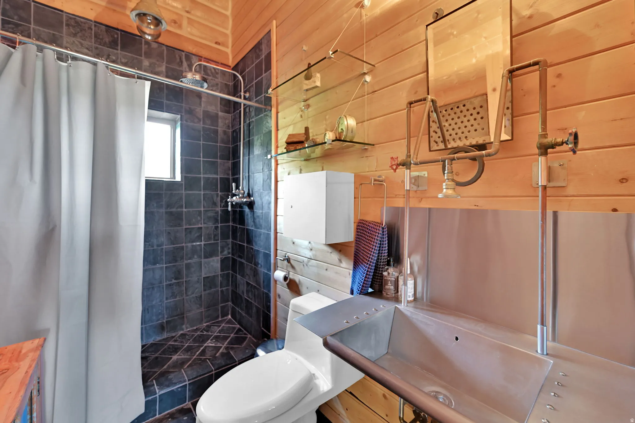 Wood-paneled walls featuring a tiled shower stall with a single window