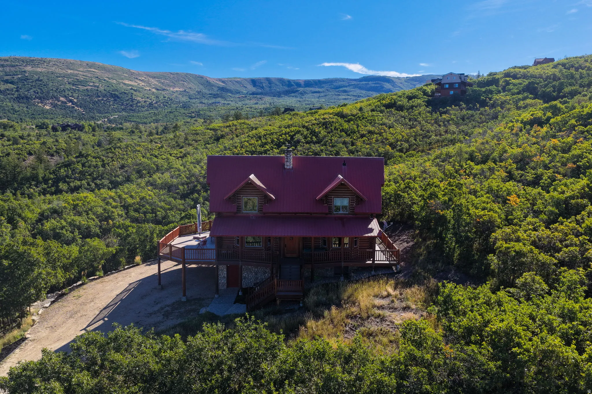 Log cabin-style residence featuring a red metal roof and multiple dormer windows