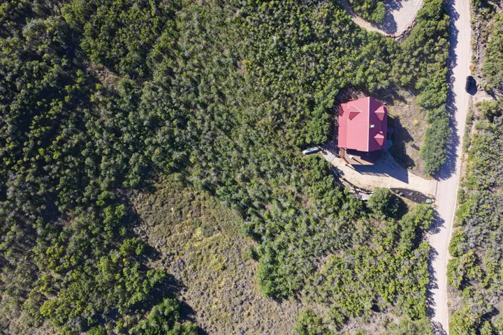 Red-roofed residence nestled amongst extensive natural landscaping