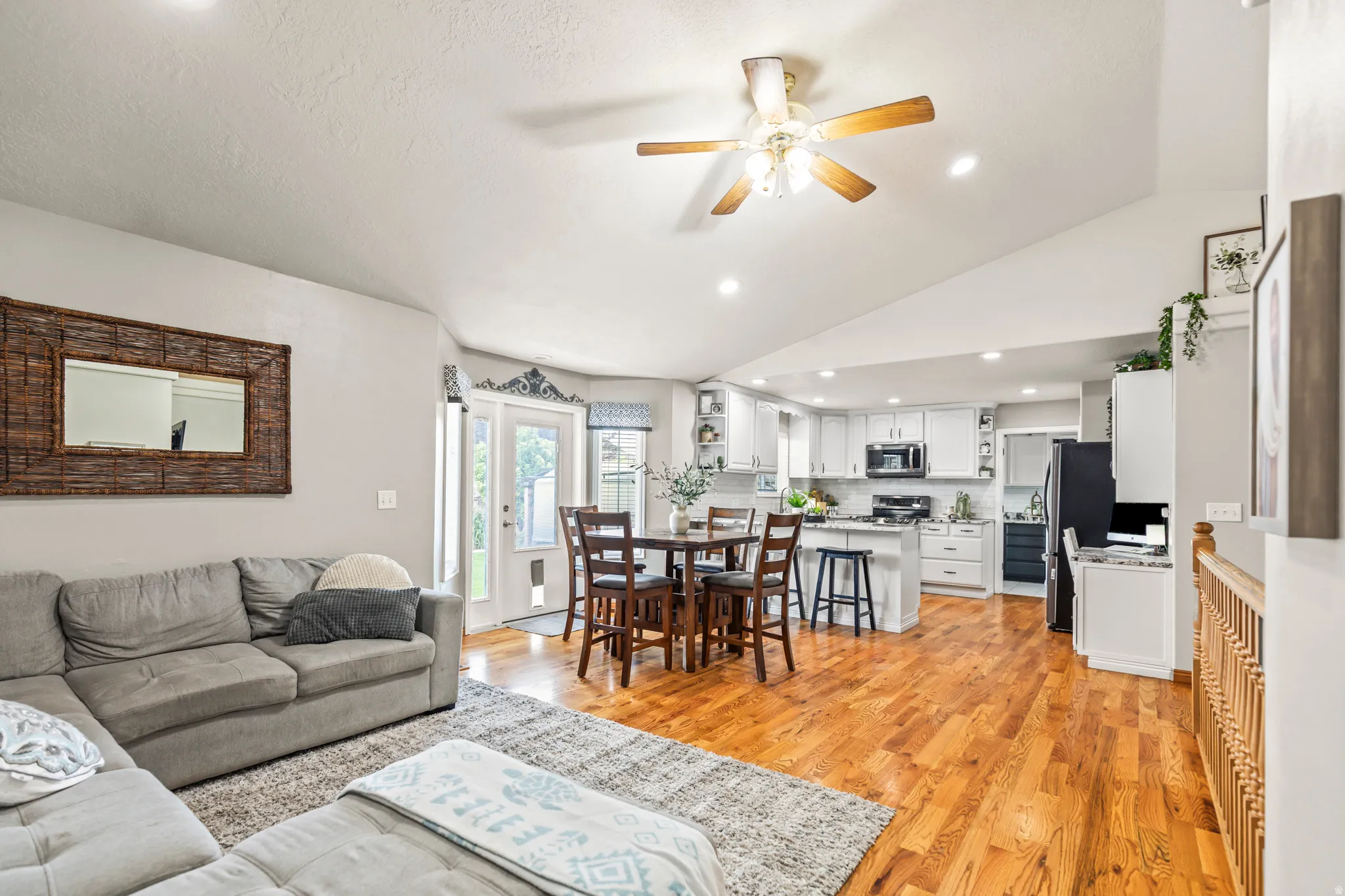 Vaulted ceilings, recessed lighting, and wood-finish flooring