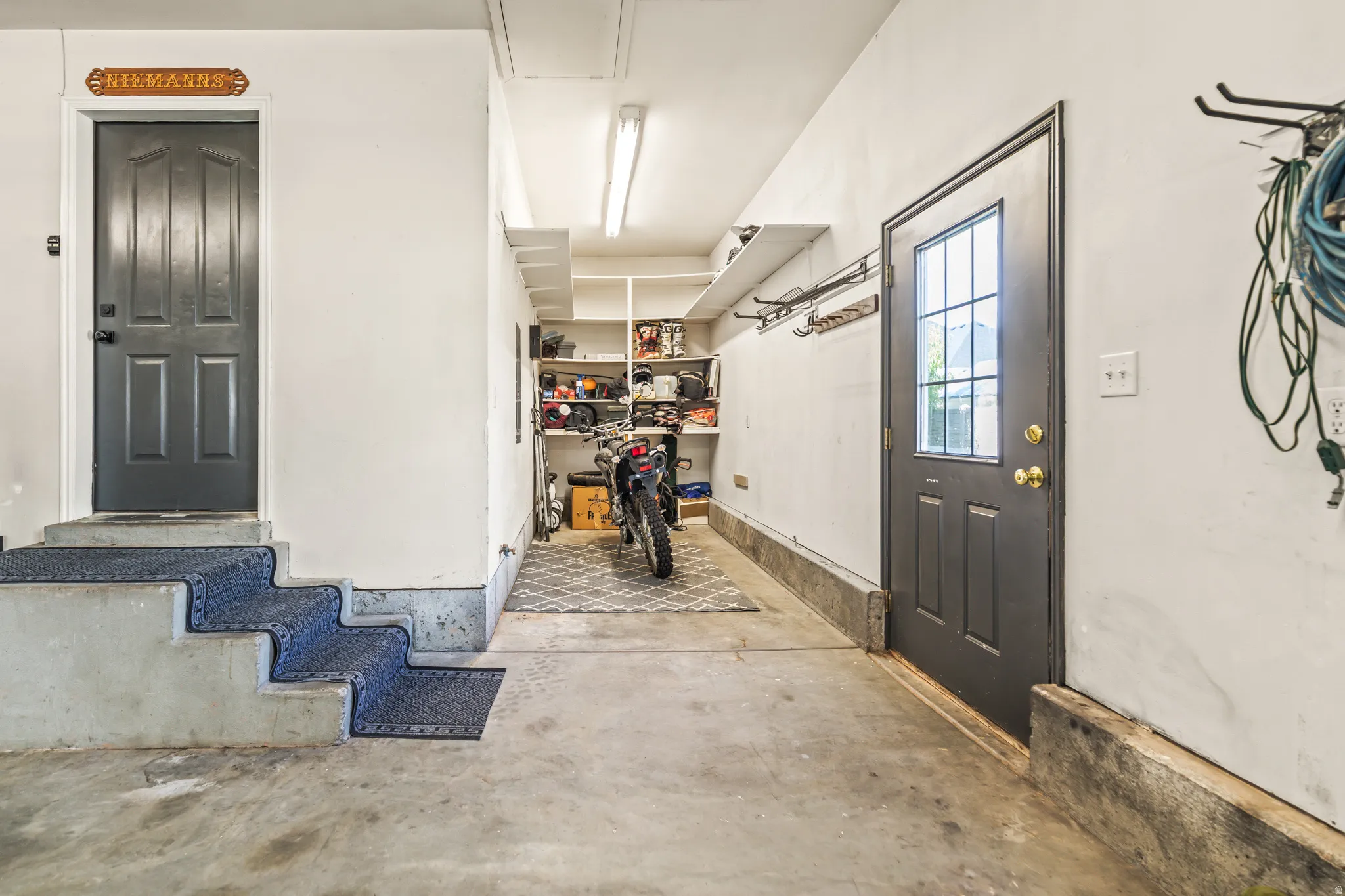 Concrete flooring with built-in storage shelving and two entry doors