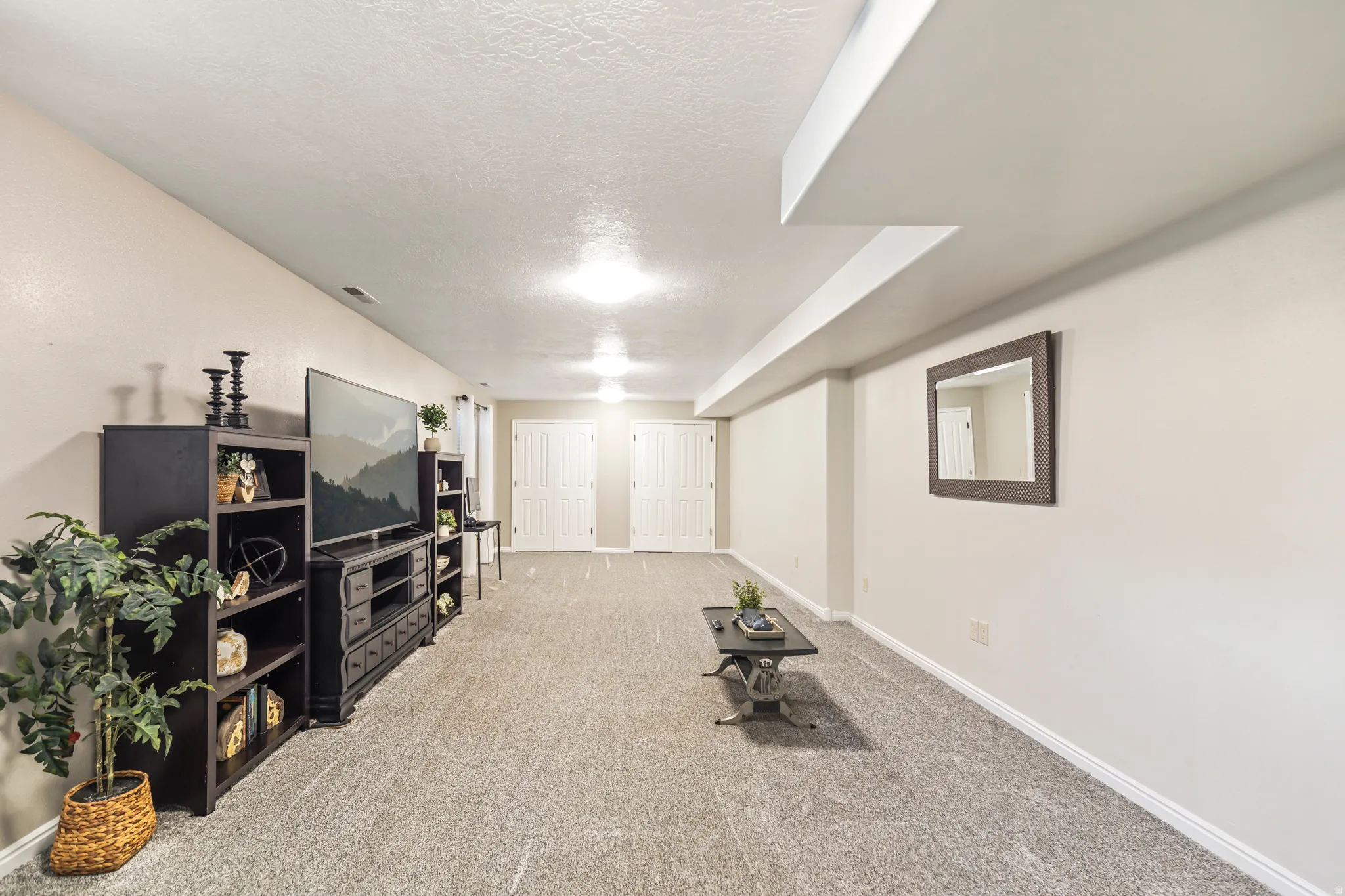 Recessed lighting, light-toned walls, and carpeted flooring