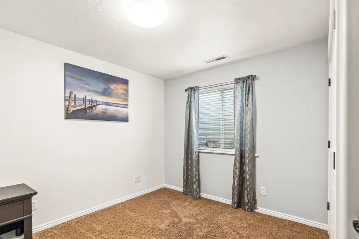 Carpeted flooring, window with blinds, ceiling-mounted light fixture, and white trim