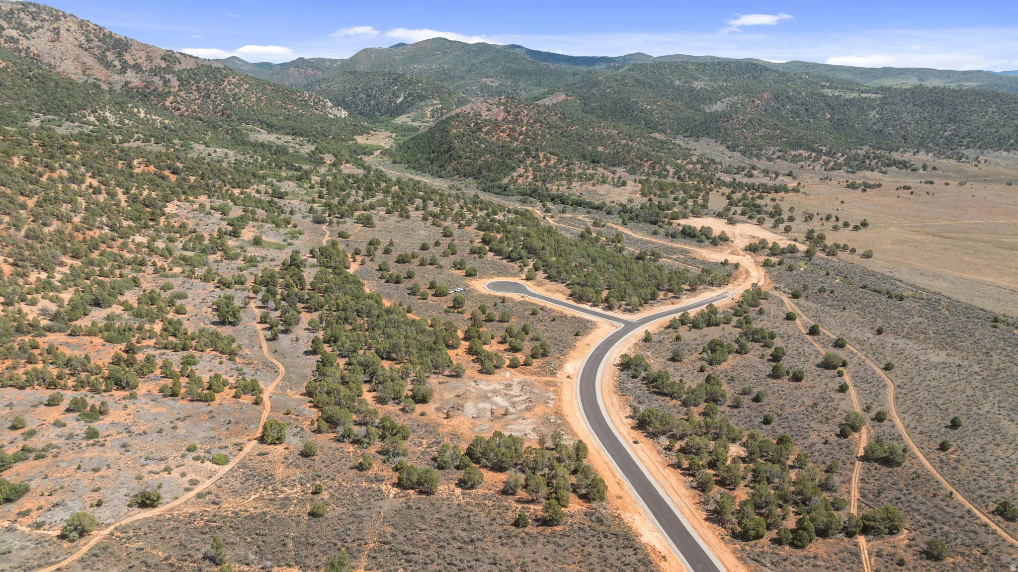 Mountainous terrain featuring diverse vegetation and newly paved roads