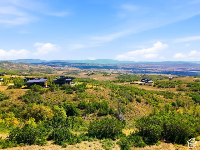 Expansive elevated terrain featuring natural landscaping and distant mountain ranges