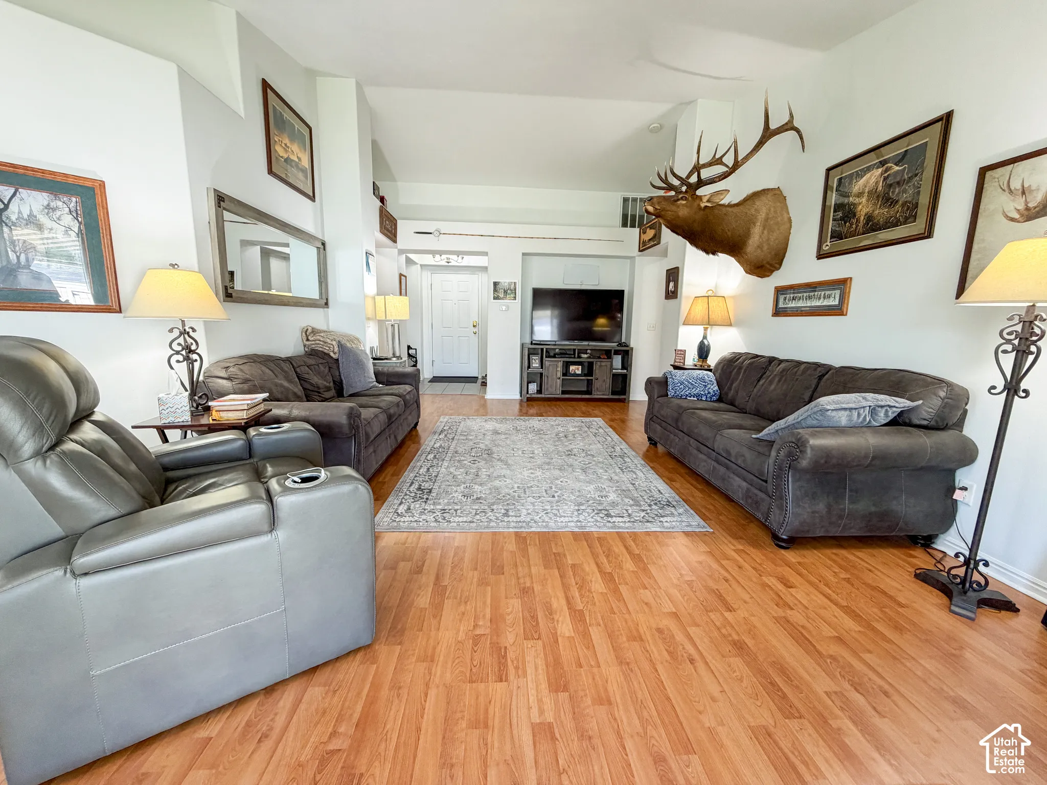 Vaulted ceilings with recessed lighting, wood-finish flooring, and white painted walls
