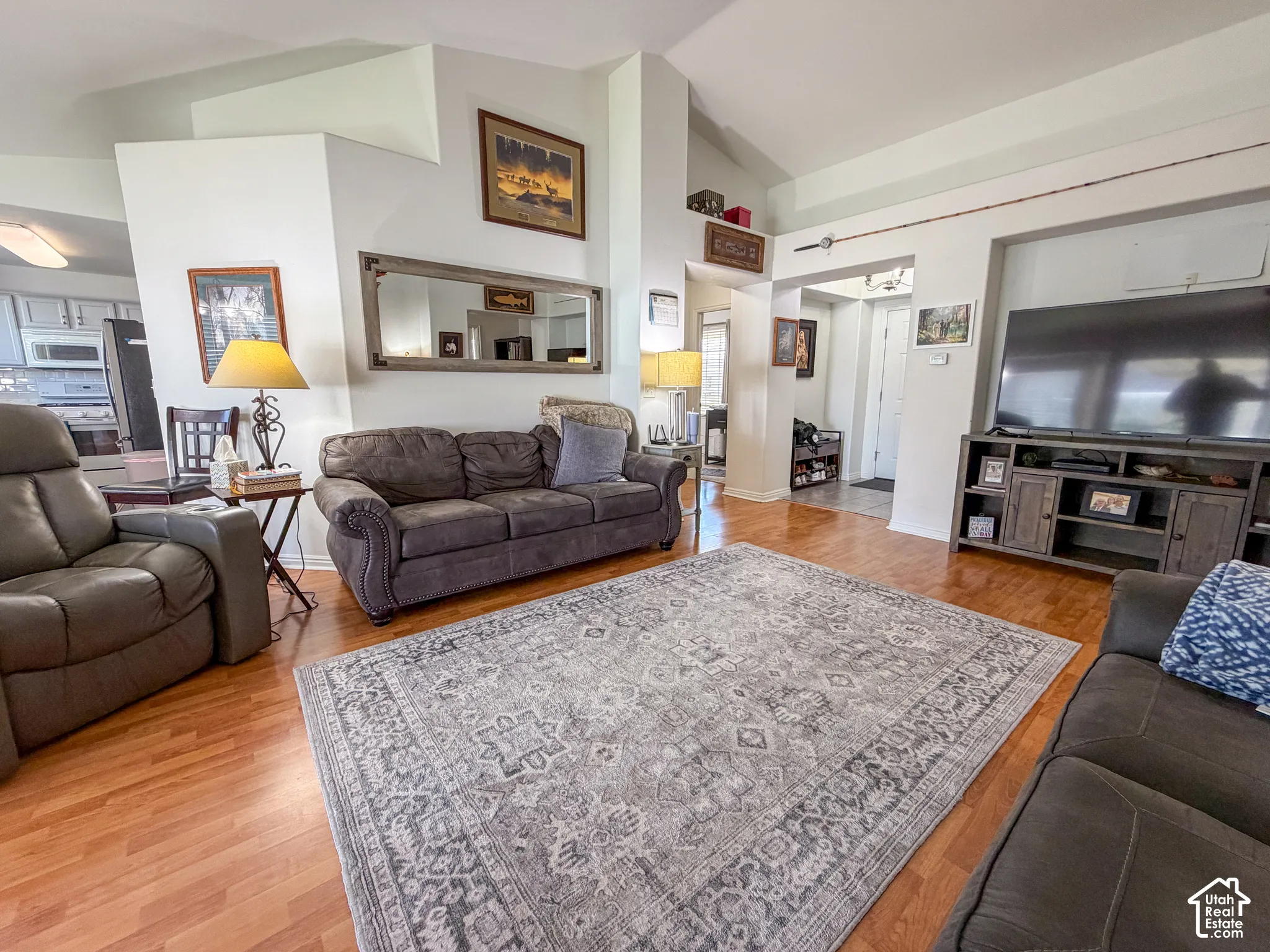 Vaulted ceilings, wood-finish flooring, and a media console with storage