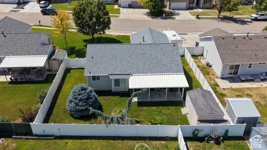 Backyard with a manicured lawn, established landscaping, and perimeter fencing