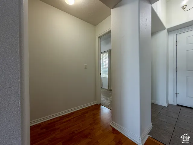 Wood-finish flooring, white baseboards, and a flush-mount ceiling light fixture