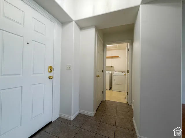 Entryway featuring a paneled door with brass hardware and tile flooring