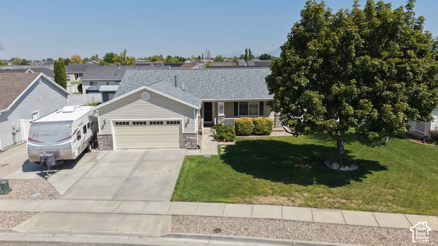 Single-story residence featuring a two-car garage, concrete driveway, and stone accents