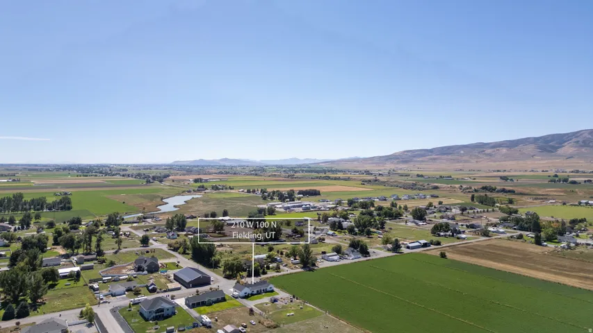 Expansive agricultural fields, distant mountains, and a clear body of water