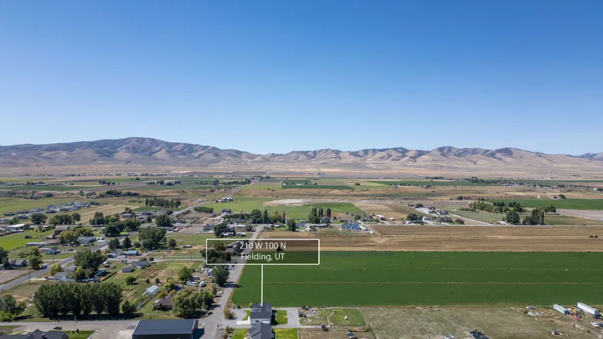 Expansive rural landscape featuring distant mountains and agricultural fields