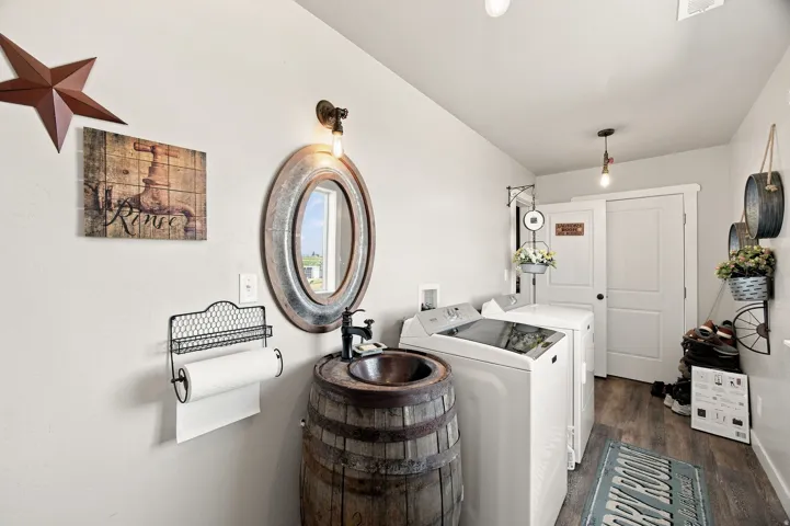 Wood-finish flooring, a barrel-style vanity with a vessel sink, an oval wall-mounted mirror, and a sliding panel door