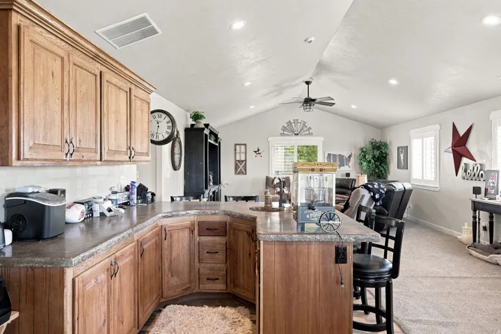 Kitchen with wood cabinetry, extensive countertop space, and a breakfast bar