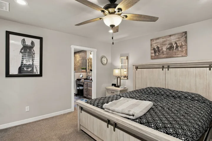 Recessed ceiling lighting, ceiling fan with integrated lighting, wall-to-wall carpeting, and an open doorway leading to a vanity area