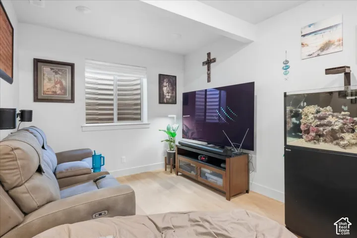 Recessed lighting, light wood-finish flooring, and a large window with horizontal blinds