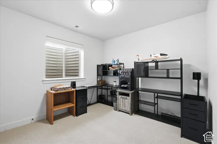 Wall-to-wall carpeting and a single overhead light fixture illuminate this room