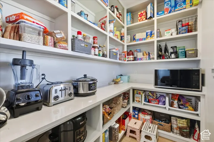 Walk in pantry extensive storage, integrated countertop space, and white finishes