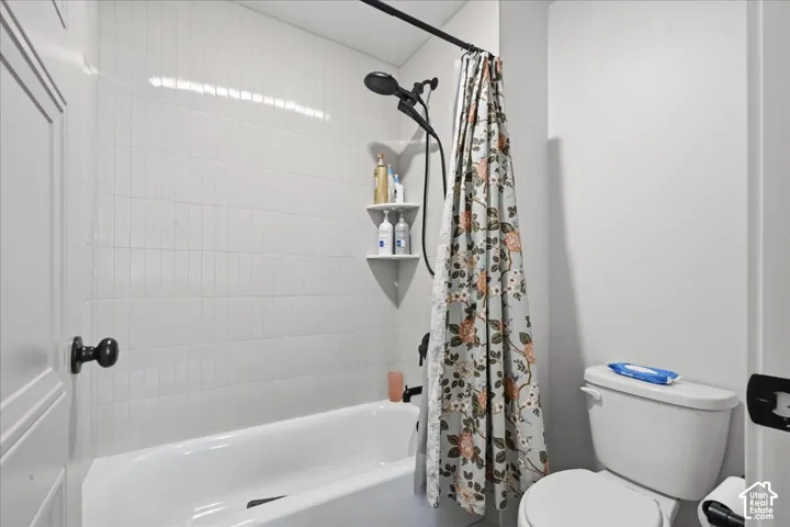 White subway tile shower surround with integrated shelving and a matte black shower fixture