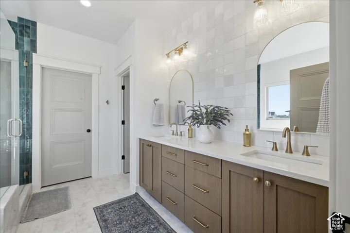 Dual vanity with undermount sinks, quartz countertop, wood-finish cabinetry, and gold-finish hardware