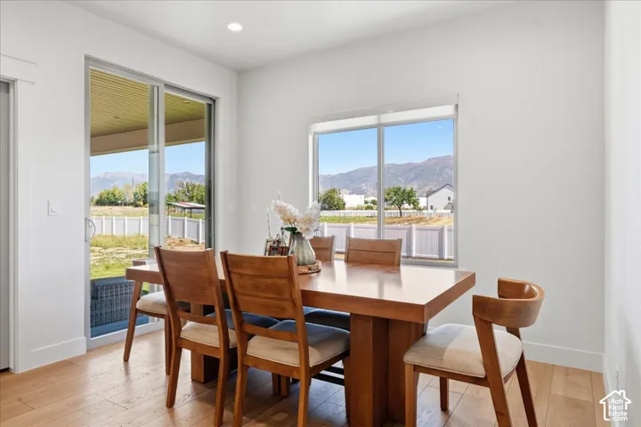Wood-finish flooring, recessed lighting, expansive sliding glass door, and large window with mountain scenery