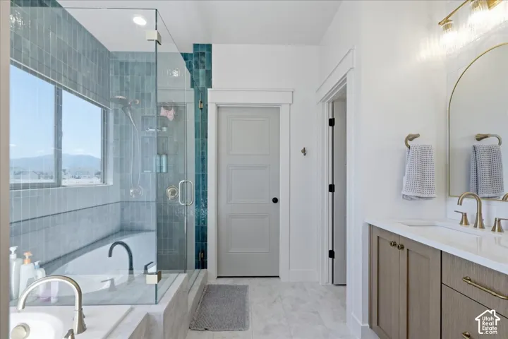 Glass-enclosed shower with subway tile, built-in bathtub, dual-sink vanity with wood-finish cabinetry, and arch-top mirror
