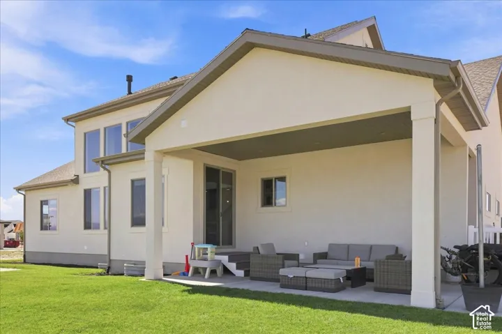 Expansive lawn area with a covered patio featuring a built-in ceiling, recessed lighting, and direct exterior access