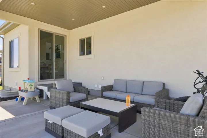 Covered patio featuring recessed lighting, a sliding glass door, and exterior windows