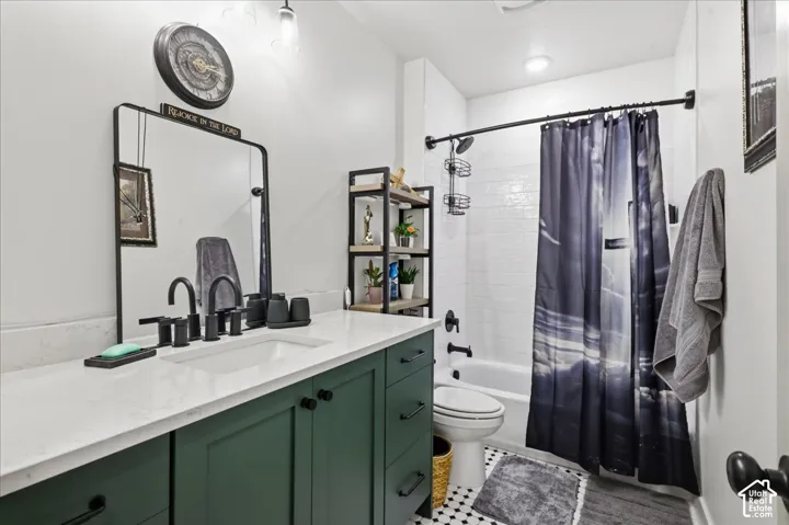 Bathroom featuring a green vanity with white countertop, undermount sink, and matte black fixtures