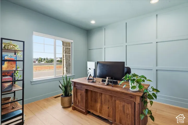 Recessed lighting, wood-finish flooring, and a large window with white trim