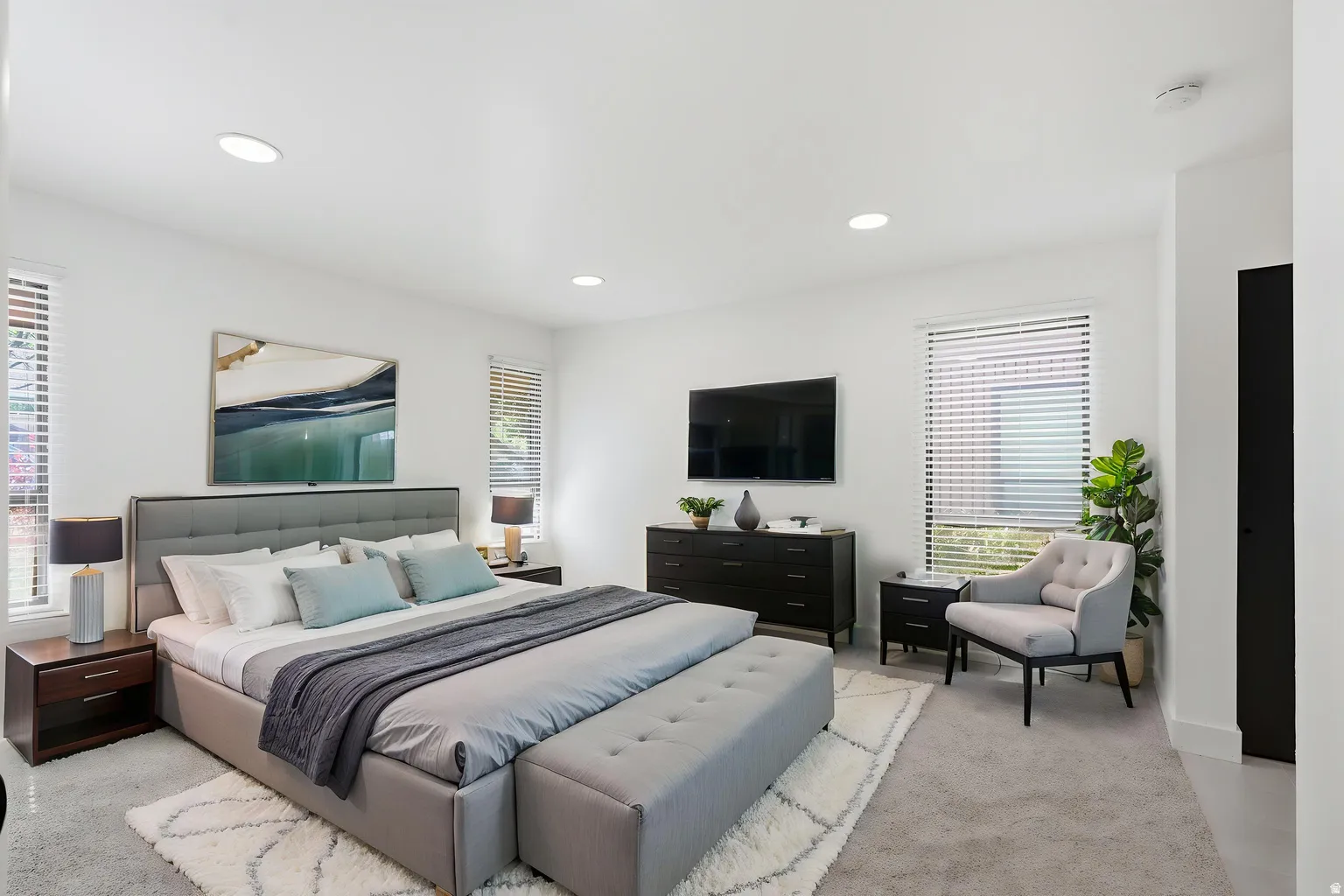 Recessed lighting, white walls, and broad windows with blinds