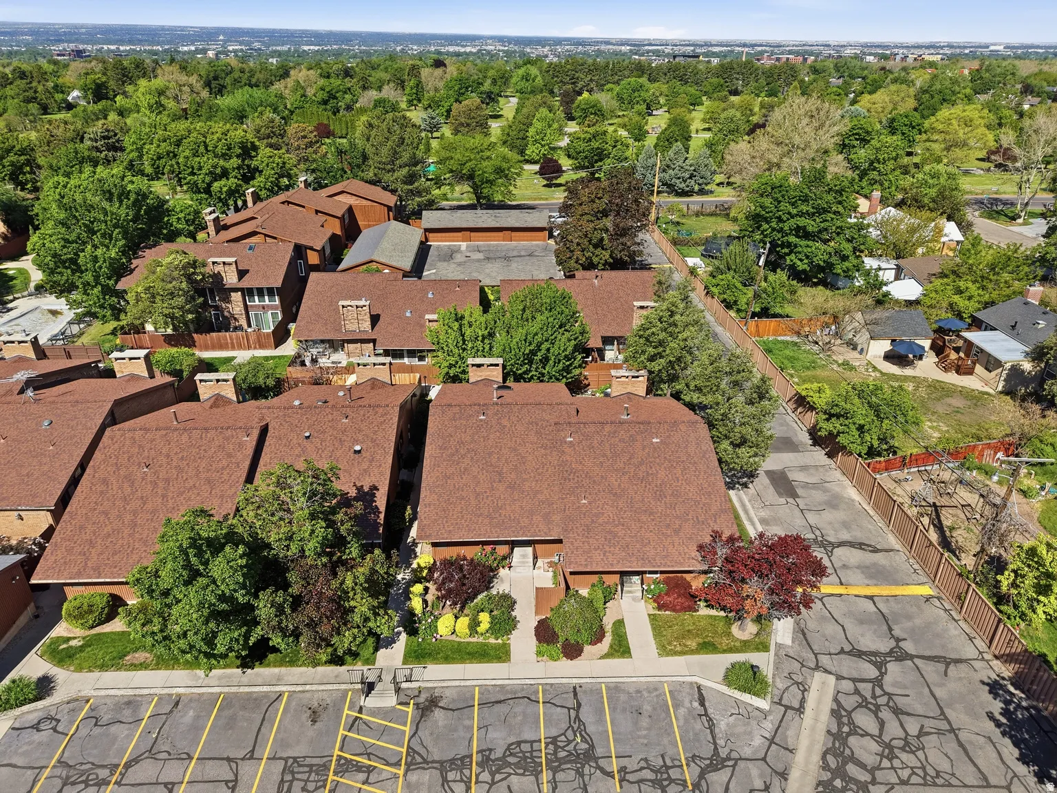 Townhome complex featuring pitched roofs and mature trees