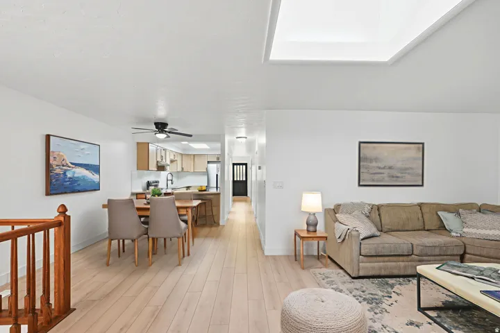 Wood-finish flooring throughout, bright white walls, recessed lighting, and a skylight feature