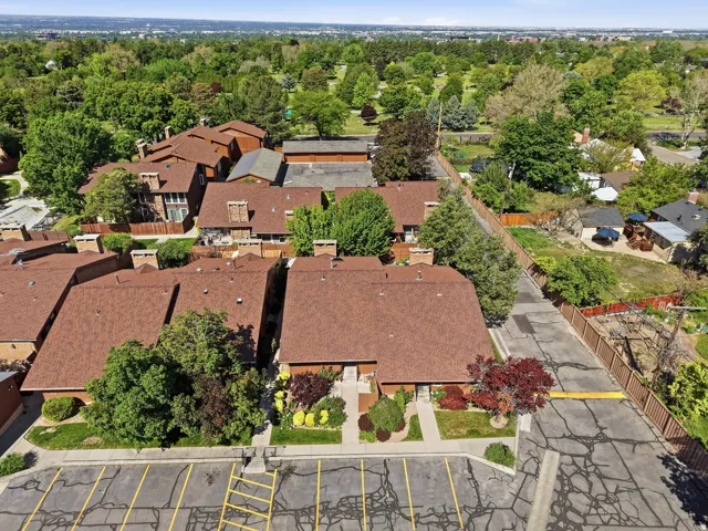 Townhome complex featuring pitched roofs and mature trees