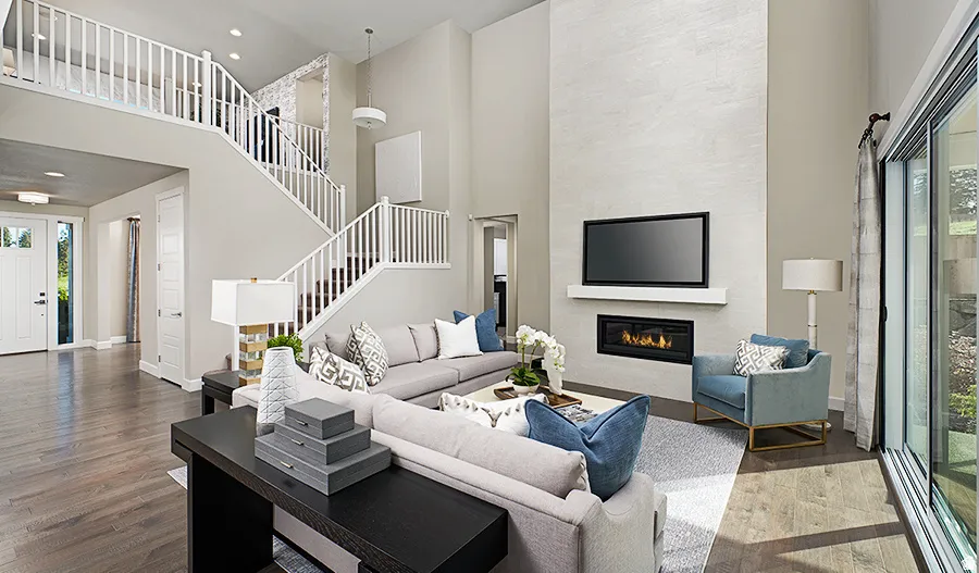 Two-story living area with wood-finish flooring, a contemporary fireplace, and an expansive sliding glass door