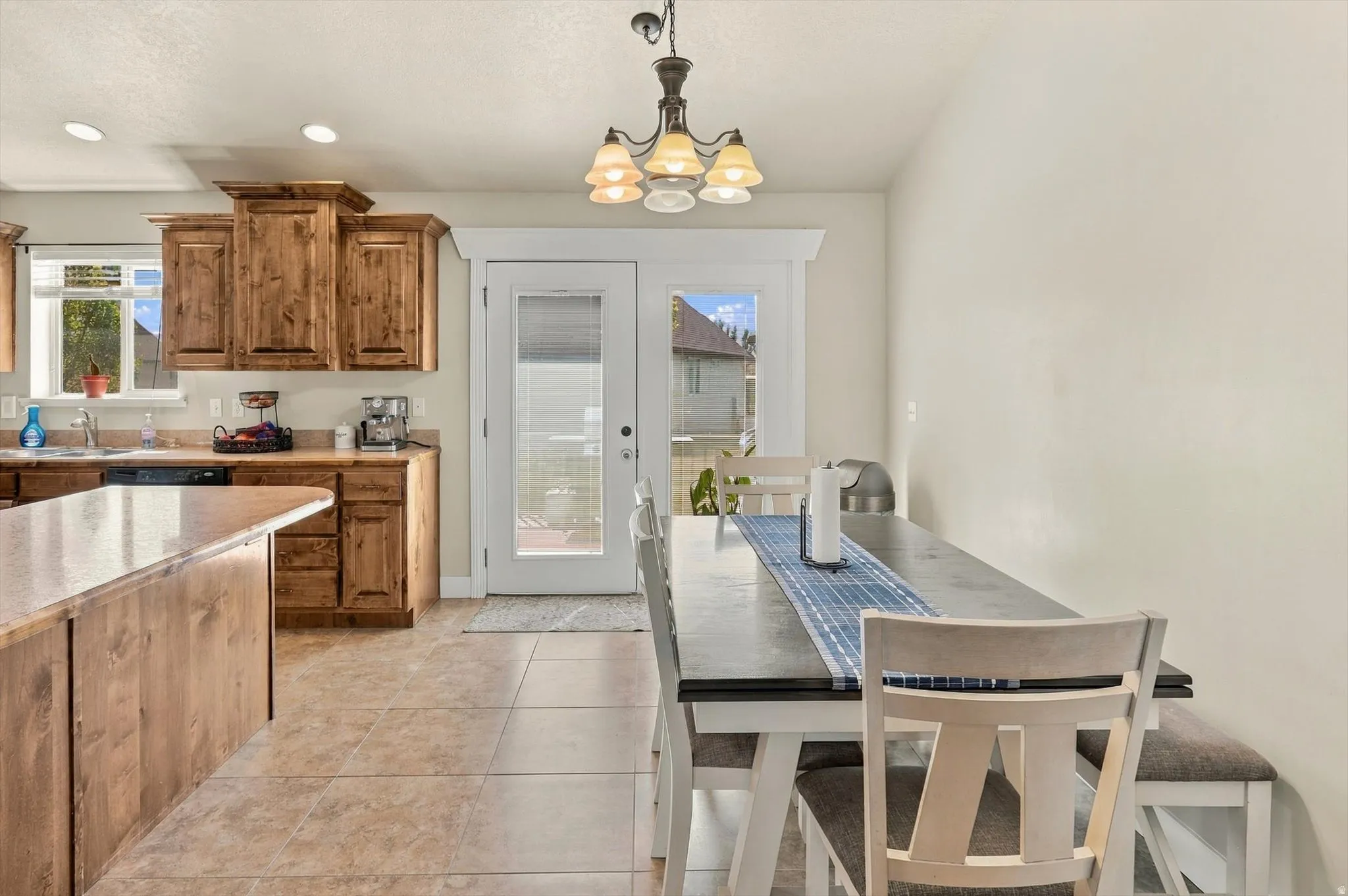 Kitchen with wood-finish cabinetry, a central island, and a sink with a window above