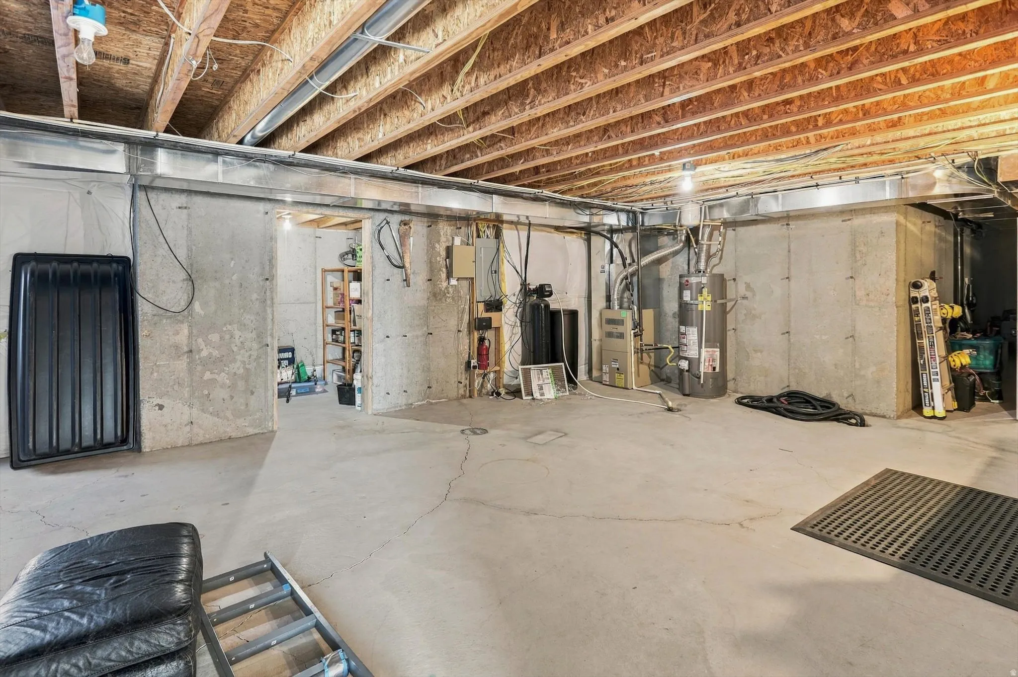 Unfinished basement with concrete flooring and exposed ceiling joists