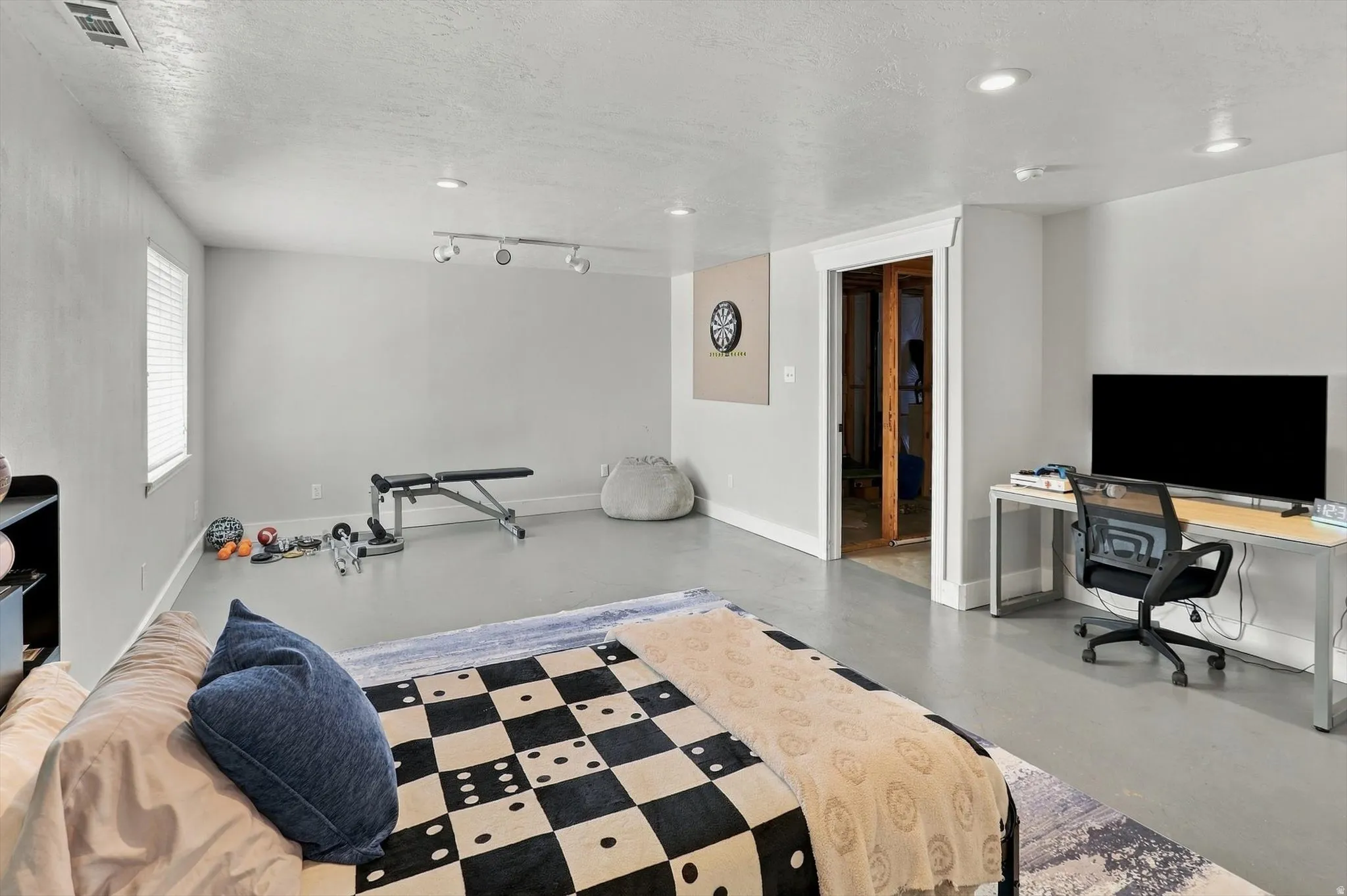 Spacious interior with light gray walls, recessed lighting, and a window with white blinds