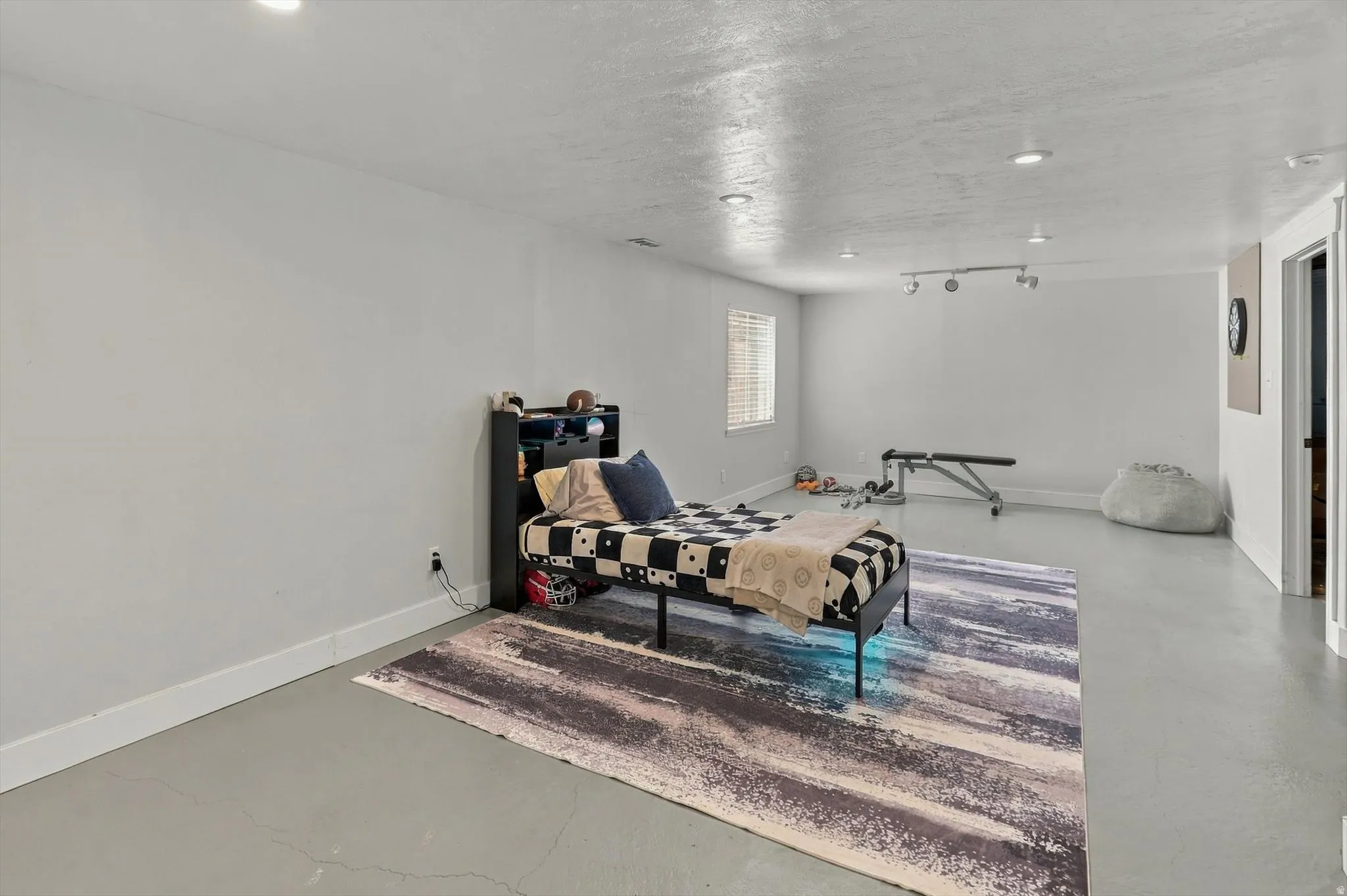 Spacious room with recessed lighting and a window featuring horizontal blinds
