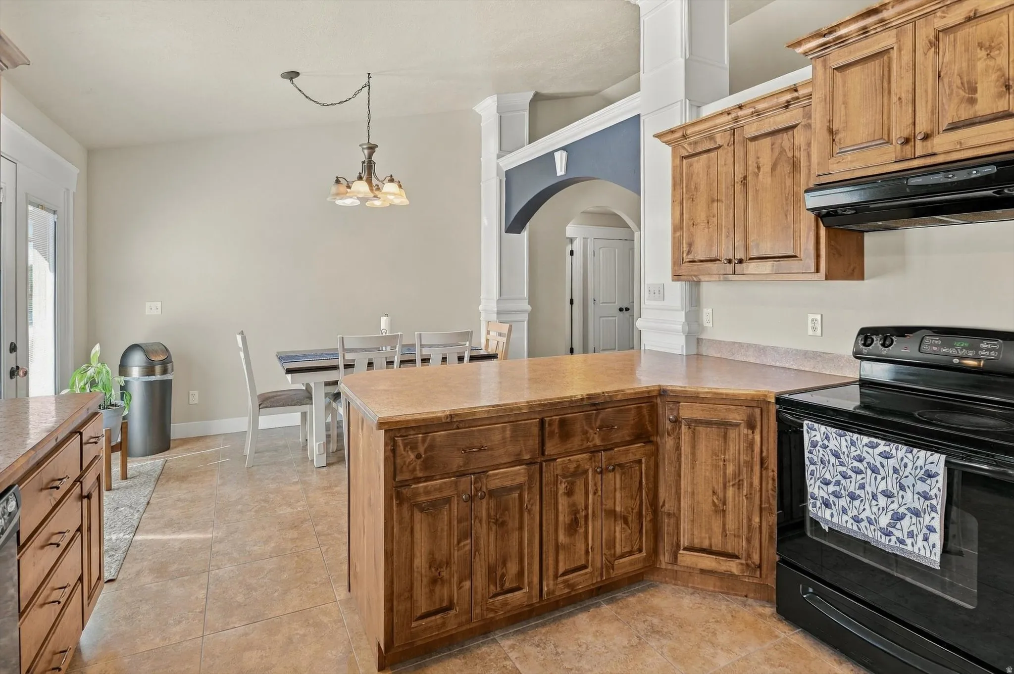 Kitchen featuring wood cabinetry, light-toned countertops, and tile flooring