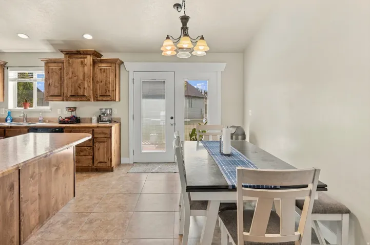 Kitchen with wood-finish cabinetry, a central island, and a sink with a window above