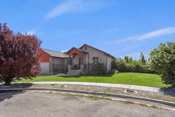 Ranch-style exterior with a covered front porch, stone accents, and an attached two-car garage